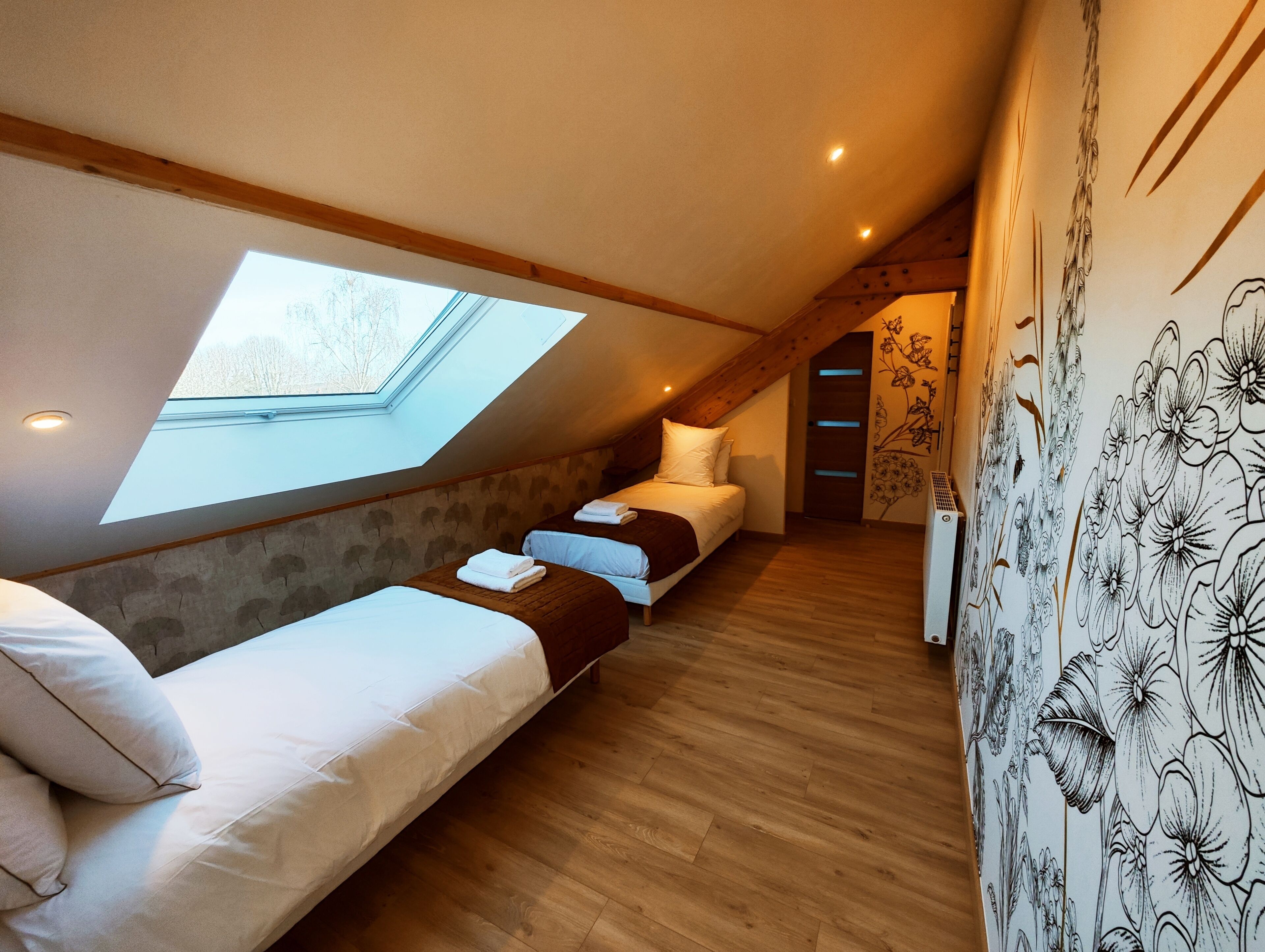 Ein Schlafzimmer mit Dachfenster, einem Bett, einer Schlafcouch und einer Heizung.