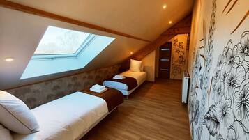Ein Schlafzimmer mit Dachfenster, einem Bett, einer Schlafcouch und einer Heizung.