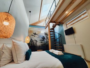 A bedroom with a bed, a wall mural, a staircase, and a skylight. - FORMOSA Dijon (Étaules)