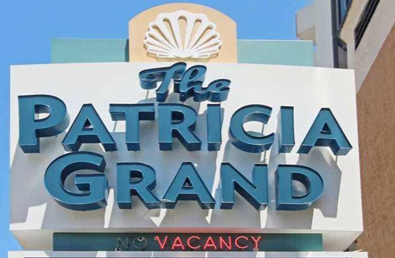 A hotel sign with the name "The Patricia Grand" and a shell logo above it.
