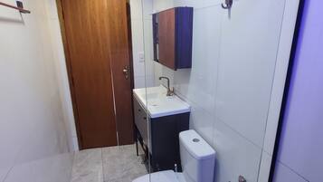 A modern bathroom with a toilet, sink, and mirror.