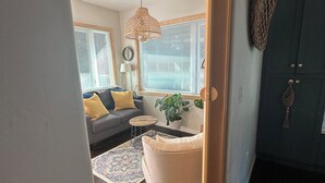 A living room with a sofa, coffee table, and a hanging light fixture.
