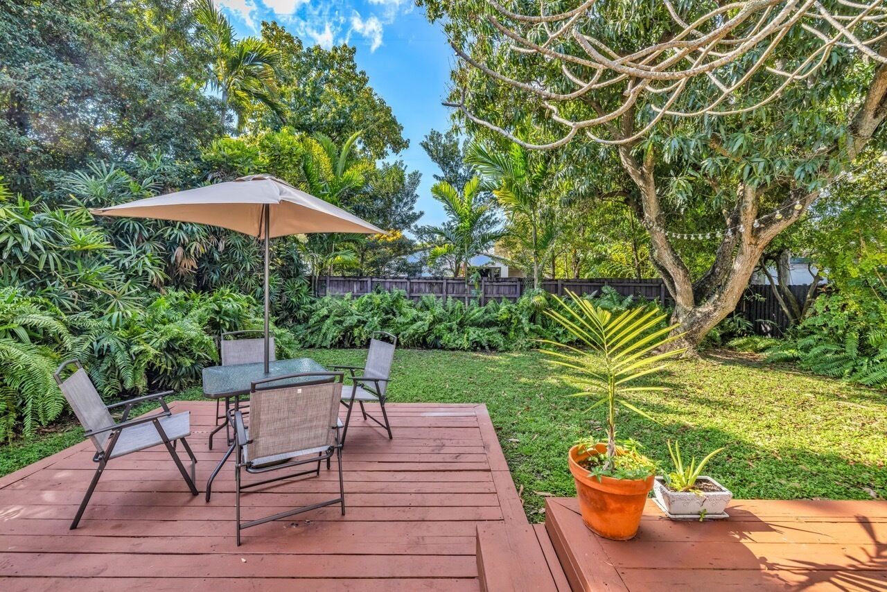 A deck with outdoor furniture and a potted plant.
