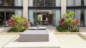 Un edificio moderno con amplios ventanales, piscina y plantas en macetas.