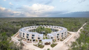 Complejo de edificios circulares con varios pisos, rodeado por un paisaje natural.