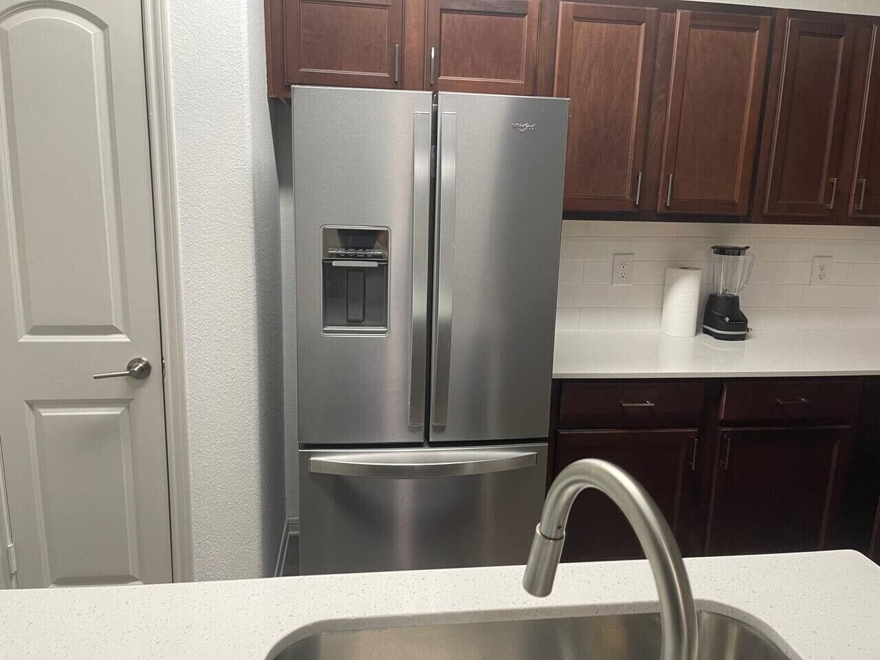 A stainless steel refrigerator with a water and ice dispenser, a built-in ice maker, and a freezer compartment.