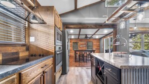 Una cocina moderna con armarios de madera, una isla central y un comedor con vistas.