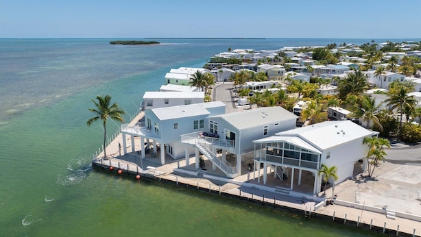 A coastal property with a dock, white buildings, and a clear view of the ocean. - Oceanfront 2BR Retreat - 35' Dock, Sunrise Views, Boater's Paradise (Cudjoe Key)