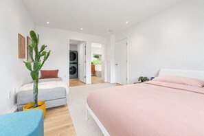 A bedroom with a bed, a sofa, a chair, and a potted plant. - Hanover Luxury MCM Retreat | Dartmouth Graduation (Hanover)