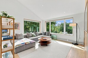 A modern living room with a sofa, coffee table, and a bookshelf. - Hanover Luxury MCM Retreat | Dartmouth Graduation (Hanover)
