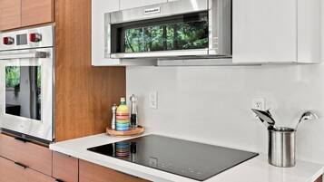 A modern kitchen with a built-in oven, a microwave, and a sleek induction cooktop.