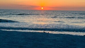 A sunset over the ocean with waves. - Private Beach Cottage Compound • Steps to Sand (Indian Rocks Beach)
