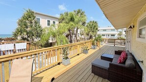 A wooden deck with outdoor furniture, a railing, and potted plants. - Private Beach Cottage Compound • Steps to Sand (Indian Rocks Beach)