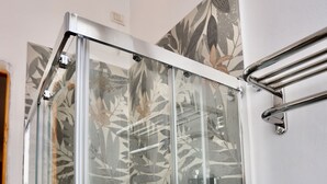 A glass-enclosed shower with a floral-patterned wall behind it. - Alex's House La Spezia Migliarina 10 min from Migliarina Station (La Spezia)