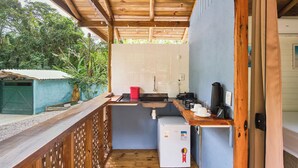 A compact kitchen with a sink, a small refrigerator, and a coffee maker.