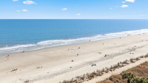 A wide beach with a clear sky, calm sea, and a few people. - Direct Oceanfront Views  2BR 2B Condo  Private Balcony  Sleeps 6 (Myrtle Beach)