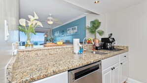 A kitchen with granite countertops, a dishwasher, a coffee maker, and a view of the ocean. - Direct Oceanfront Views  2BR 2B Condo  Private Balcony  Sleeps 6 (Myrtle Beach)