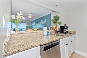 A kitchen with granite countertops, a dishwasher, a coffee maker, and a view of the ocean. - Direct Oceanfront Views 2BR 2B Condo Private Balcony Sleeps 6 (Myrtle Beach)