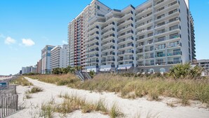 A multi-story hotel with balconies, located near a sandy beach area. - Direct Oceanfront Views  2BR 2B Condo  Private Balcony  Sleeps 6 (Myrtle Beach)