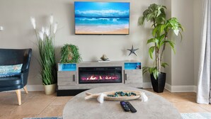 A living room with a fireplace, a television, a sofa, and a coffee table. - Direct Oceanfront Views  2BR 2B Condo  Private Balcony  Sleeps 6 (Myrtle Beach)