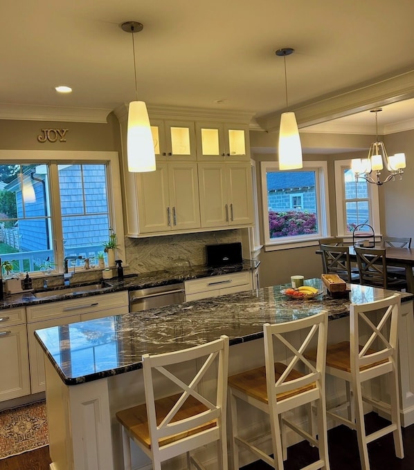 A modern kitchen with a large island, white cabinetry, and pendant lighting. - Luxury Coastal Retreat ✨ 5 min to Beach,Sleeps 10,BBQ + Patio (Long Branch)