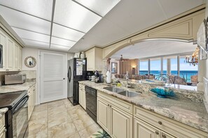 A spacious kitchen with a large island, modern appliances, and a view of the ocean. - 2BR Beachfront Condo Long Beach Resort 6th Floor On Site Snack Bar (Panama City Beach)