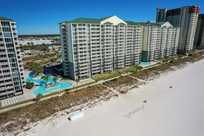 A high-rise hotel with multiple balconies, a swimming pool, and a beach view. - 2BR Beachfront Condo Long Beach Resort 6th Floor On Site Snack Bar (Panama City Beach)
