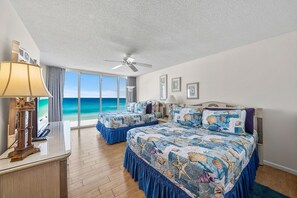 A hotel room with a large bed, a ceiling fan, and a view of the ocean. - 2BR Beachfront Condo Long Beach Resort 6th Floor On Site Snack Bar (Panama City Beach)