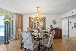 A dining room with a chandelier, a large mirror, and a view of the ocean. - 2BR Beachfront Condo Long Beach Resort 6th Floor On Site Snack Bar (Panama City Beach)