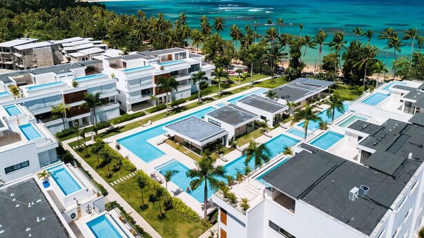 A resort with multiple swimming pools, modern architecture, and a view of the ocean. - Penthouse 3BR Ocean View & Pool | Sol de Arena F7 (Las Terrenas)