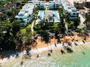 Un complexe hôtelier comprenant plusieurs bâtiments, une piscine et une plage.