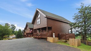 A log cabin-style building with a porch, a flag, and a wooden fence. - Million Dollar Majestic View with best views around!!!! (Sevierville)