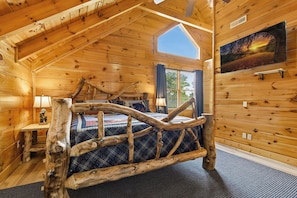 A log cabin bedroom with a bed, a window, and a painting on the wall. - Million Dollar Majestic View with best views around!!!! (Sevierville)