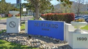 Schild für Silverado Resort mit freier Sicht auf den Eingang, einen Steinweg und einen Parkplatz.
