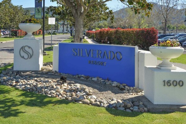 A sign for Silverado Resort with a large blue sign and a white pillar with a logo. - Luxury stay,  views galore & pool. Walk to resort dining. (Napa)