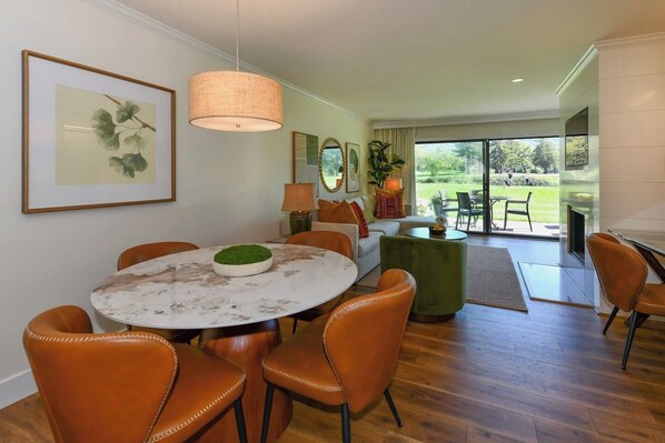 A dining area with a round table, chairs, and a green centerpiece. - Luxury stay,  views galore & pool. Walk to resort dining. (Napa)