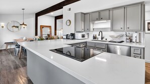 Una cucina moderna con una grande isola, elettrodomestici in acciaio inox e un design minimalista.