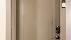 A closed elevator door with a metallic handle and a small control panel on the right side. - Modern 1200sf 2bed apto in Frisco (Frisco)