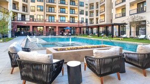 A poolside area with outdoor seating and a fire feature. - Modern 1200sf 2bed apto in Frisco (Frisco)