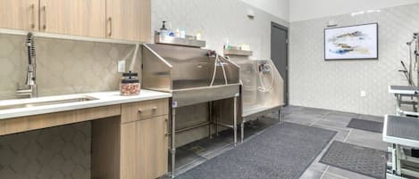 Una cocina moderna con electrodomésticos de acero inoxidable, un armario de madera y suelo de baldosas.
