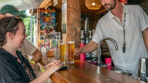 Et område med bar, træbjælker og en person, der hælder et drikkemøde.