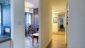 A hallway with a bicycle, a dining table, and a lamp. - Apartmentby the sea - 4 guests (Châtelaillon-Plage)