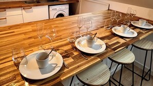 Une cuisine moderne dotée d’un long plan de travail en bois, d’un lave-linge encastré et d’une lucarne.