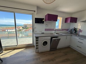 A modern kitchen with a washing machine, a sink, and purple cabinets. - Apartment panoramic sea view - 5 guests (Le Barcarès)