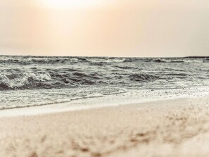 Een strand met golven en een heldere lucht.