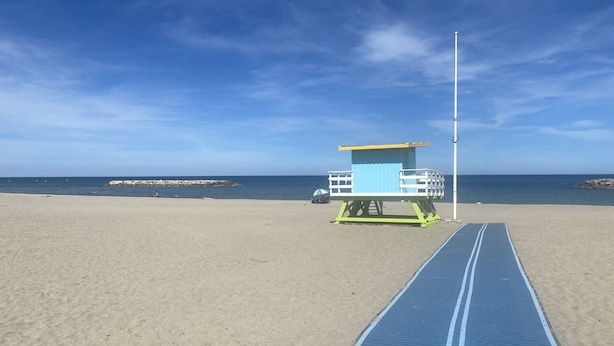 Una torretta di salvataggio su una spiaggia, con cielo sereno.