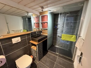 A modern bathroom with a shower, toilet, and storage cabinets. - Villa with serene lake view (Le Barcarès)