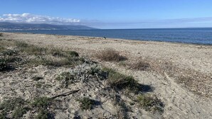 Una spiaggia con vista libera sull'oceano e montagne lontane.