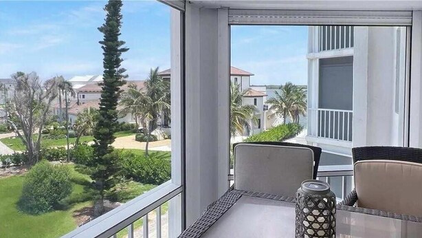 Un balcon avec une table, des chaises et un vase décoratif.