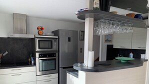 Eine moderne Küche mit Einbau-Mikrowelle, Backofen und Kühlschrank.